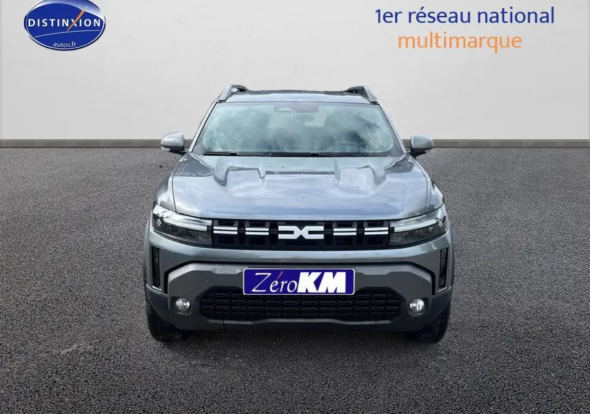 Vue avant d'un Dacia Duster gris schiste 2025 avec calandre noire et phares LED fins, sur fond neutre.