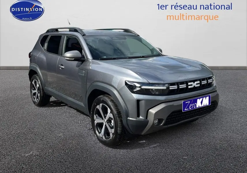 Vue 3/4 avant d'un Dacia Duster gris schiste avec barres de toit et jantes alu distinctives.