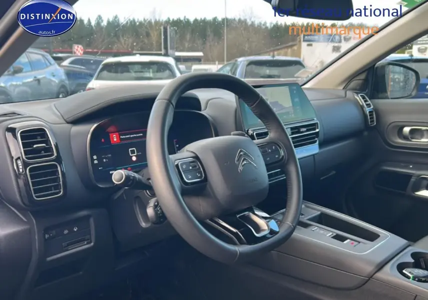 Vue intérieure côté conducteur du Citroën C5 Aircross noir 2025, volant cuir multifonction et écran tactile central.