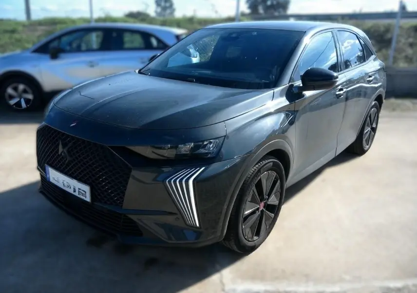 DS7 E-TENSE gris en 3/4 avant droit, avec calandre noire distinctive et feux LED verticaux marquants.