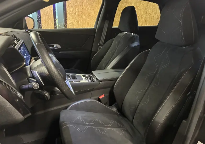 Vue intérieure côté gauche du DS7 E-TENSE 2024, sièges noirs en alcantara avec surpiqûres décoratives visibles.