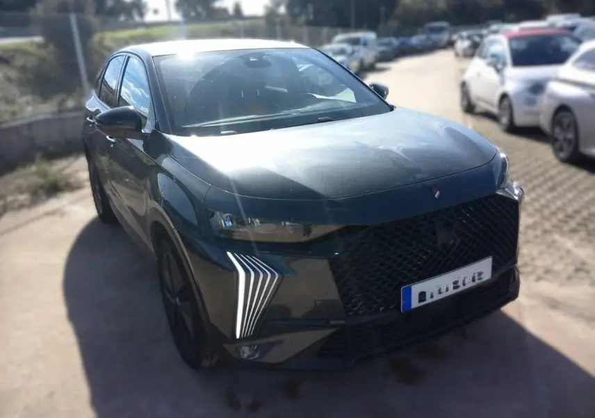 DS7 E-TENSE gris en 3/4 avant droit, mettant en valeur la calandre noire et les feux LED verticaux distinctifs.