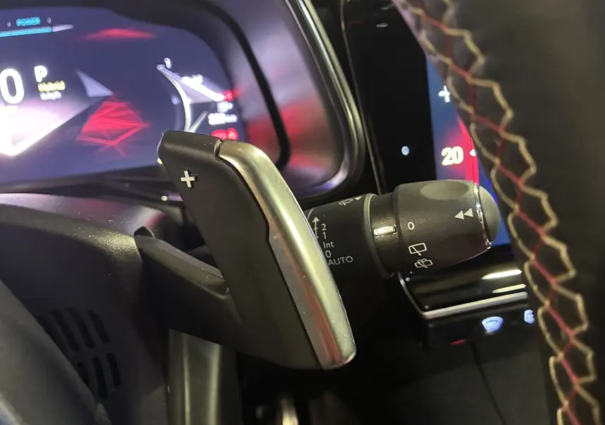 Gros plan sur la palette de changement de vitesse droite et le commodo d’essuie-glace du DS7 E-TENSE 2024 intérieur noir.