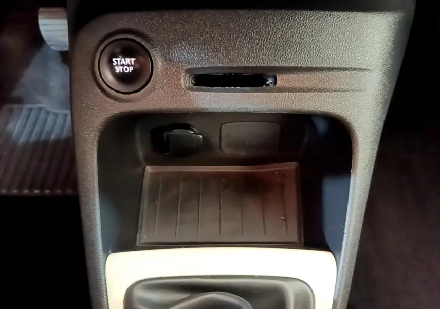 Gros plan intérieur sur la console centrale du Renault Captur gris foncé, avec bouton Start/Stop et prise 12V visible.