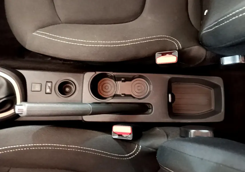 Vue plongeante sur la console centrale noire du Renault Captur gris foncé, avec frein à main et porte-gobelets.