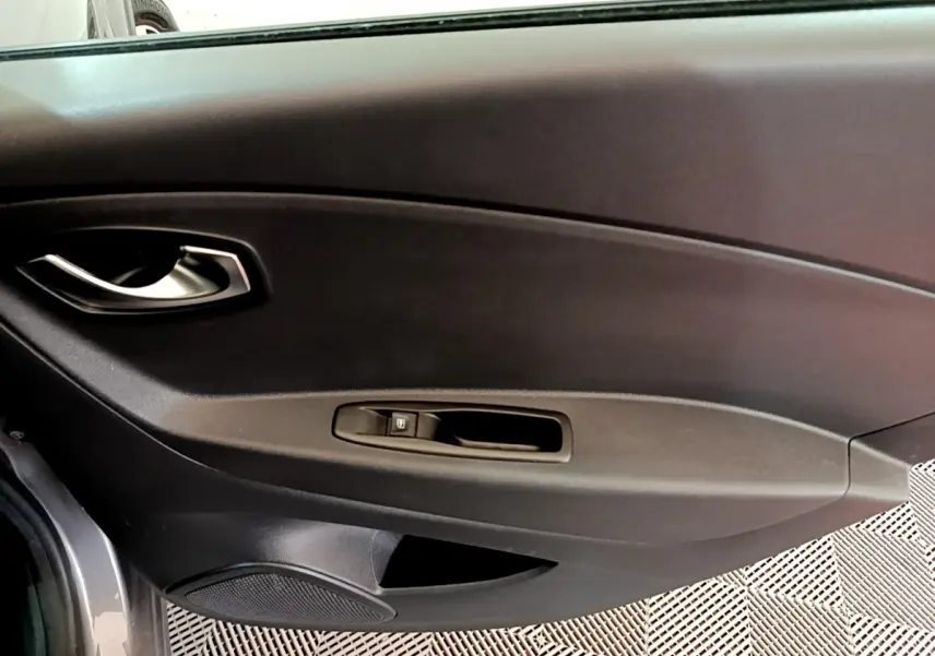 Vue intérieure côté gauche de la porte avant gris foncé du Renault Captur avec poignée et commande de vitre électrique.