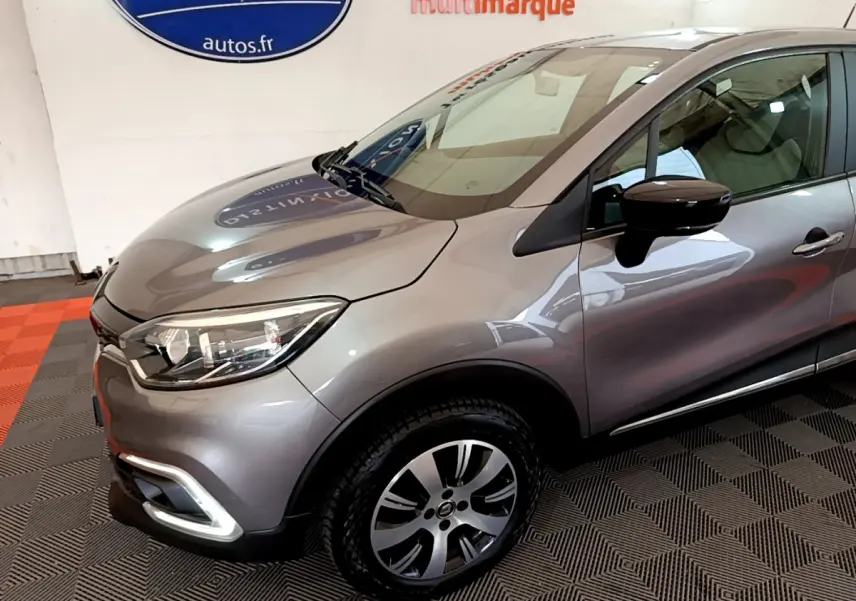 Vue 3/4 avant droit d'un Renault Captur Business gris foncé avec phares ellipsoïdaux et jantes alliage.