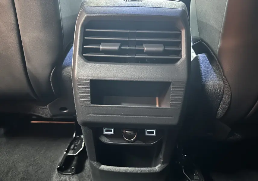 Vue rapprochée de la console arrière noire du Citroën C5 Aircross II Hybrid avec bouches d’aération et ports USB.