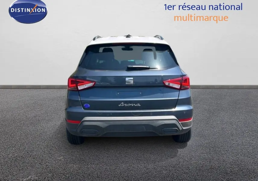 Vue arrière d’un SEAT Arona gris Magnetic Metal avec toit blanc, feux arrière LED et logo central visible.