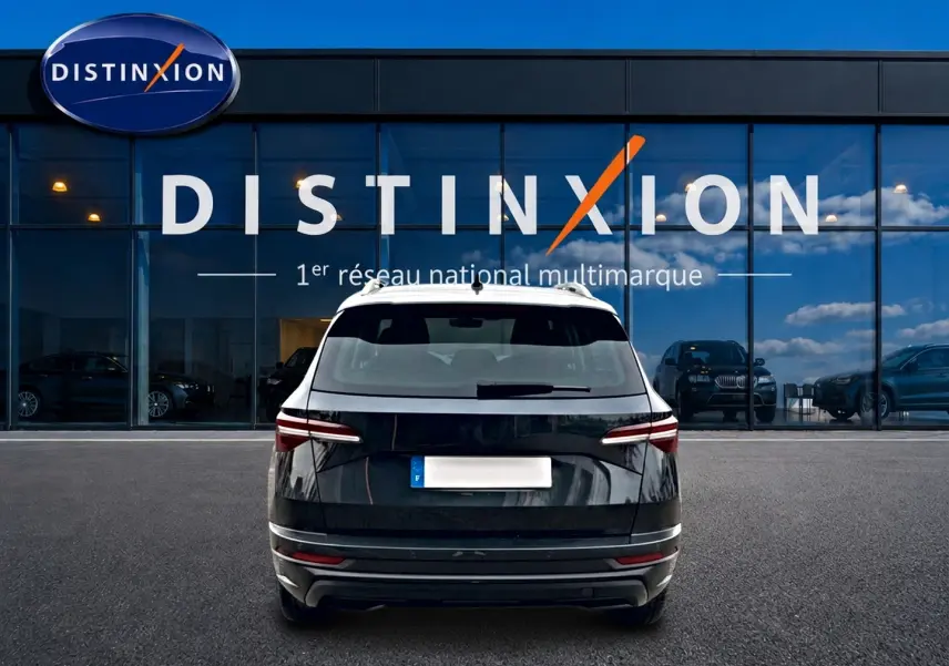 Vue arrière d'un Skoda Karoq noir 2025 garé devant une vitrine avec logo Distinxion.