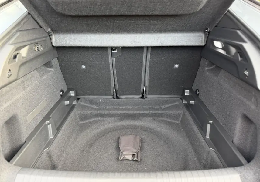 Coffre ouvert en vue plongeante du Peugeot 3008 Hybrid blanc, montrant un espace de rangement vide et propre.