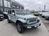 Jeep Wrangler Unlimited 2023 vert métal en 3/4 avant, hybride rechargeable, avec calandre à sept fentes et roues tout-terrain.