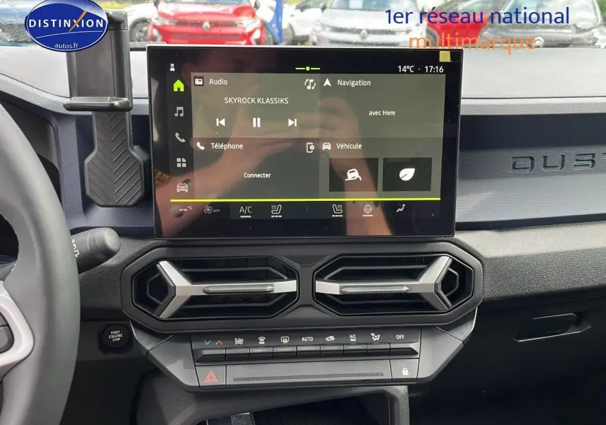 Tableau de bord du Dacia Duster gris schiste 2025 avec écran tactile central et aérateurs hexagonaux.