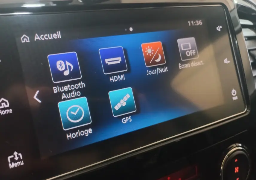 Écran tactile central du Mitsubishi L200 gris foncé, affichant les options Bluetooth, GPS et réglages jour/nuit.
