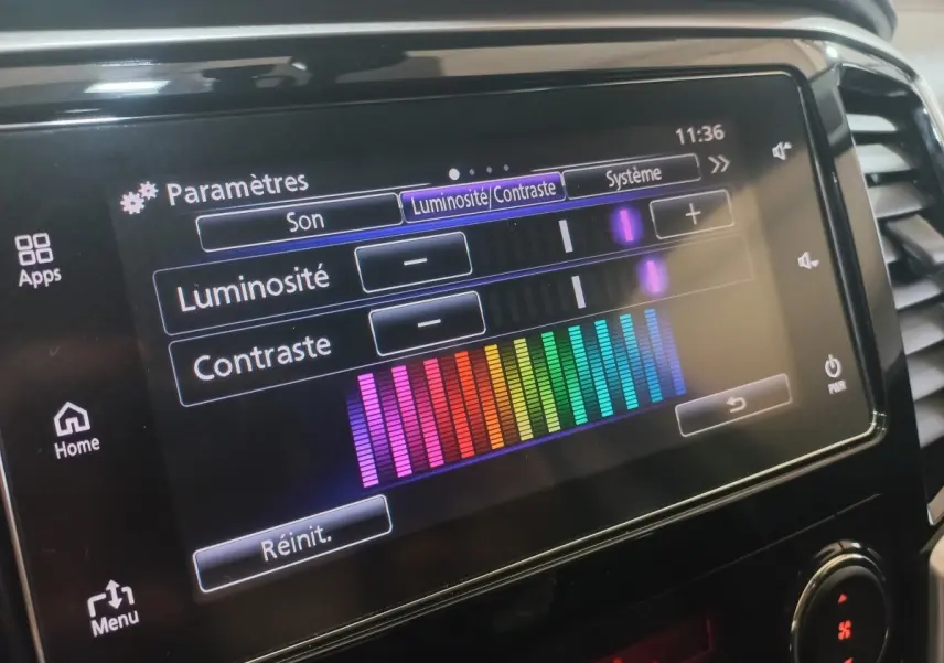 Écran tactile central du Mitsubishi L200 gris foncé, affichant les réglages de luminosité et contraste.