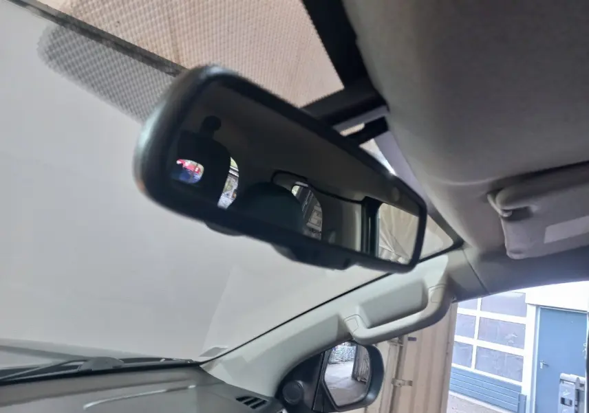 Vue intérieure du rétroviseur central et du pare-brise du Mitsubishi L200 gris foncé, côté conducteur visible.