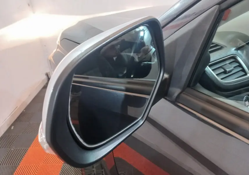 Rétroviseur côté gauche du Mitsubishi L200 gris foncé, vue rapprochée avec partie de l'habitacle visible.