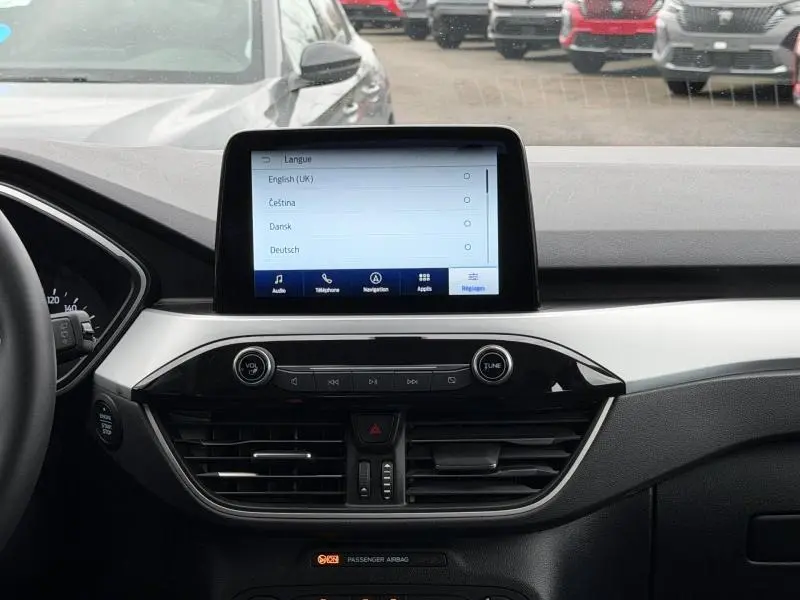 Vue intérieure du tableau de bord du Ford Kuga 2024, écran tactile central allumé, finition Titanium en noir et gris.