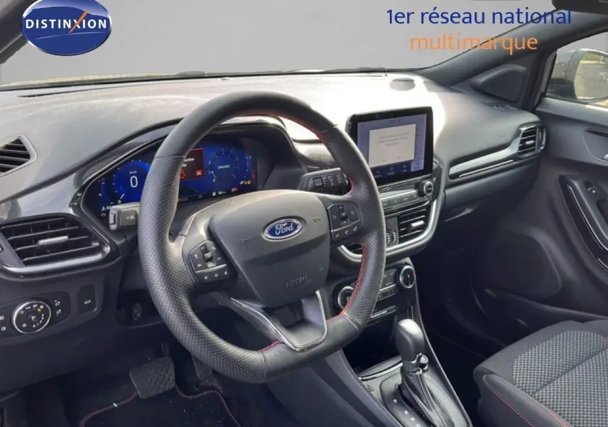 Vue intérieure du tableau de bord et volant de la Ford Puma noir agate métal avec écran tactile et boîte automatique.