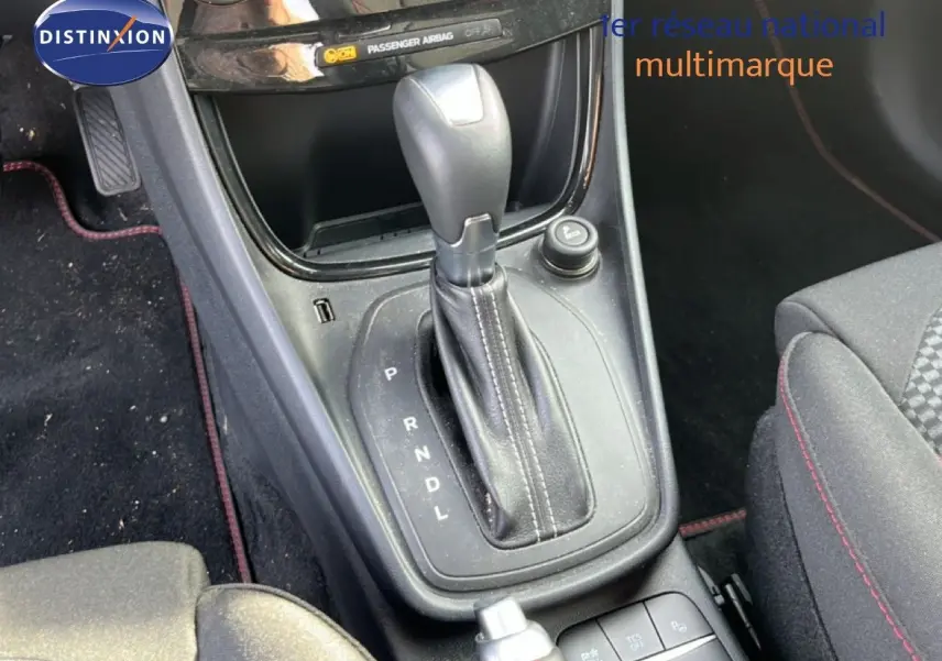 Vue rapprochée de la console centrale du Ford Puma noir agate, mettant en valeur le levier de vitesses automatique et les commandes adjacentes.
