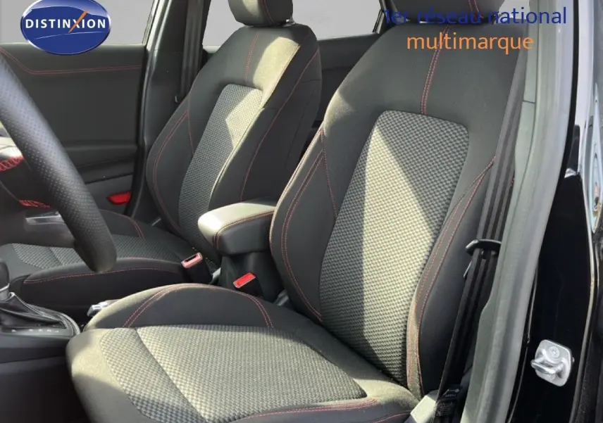 Vue intérieure côté avant droit du Ford Puma noir Agate Metal, mettant en valeur les sièges tissu noir avec surpiqûres rouges.