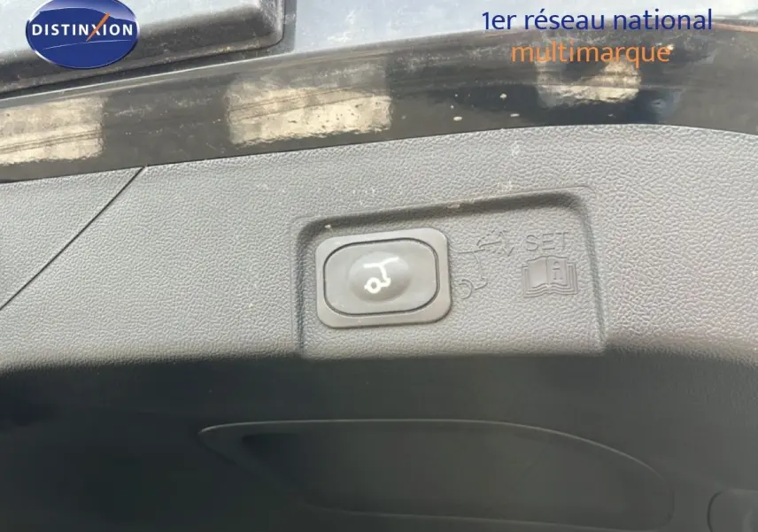 Bouton d'ouverture électrique du hayon sur le bord intérieur du coffre d'un Ford Puma noir Agate Metal 2023.
