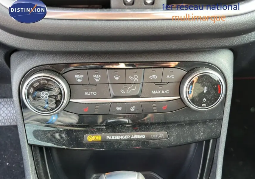 Vue rapprochée de la console centrale du Ford Puma noir agate, montrant les commandes de climatisation et chauffage.