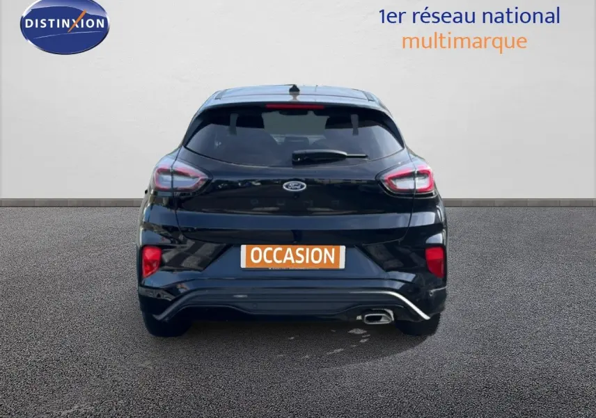 Vue arrière d'un Ford Puma noir Agate Métal 2023 avec feux LED et sortie d'échappement visible sur un sol bitumé.