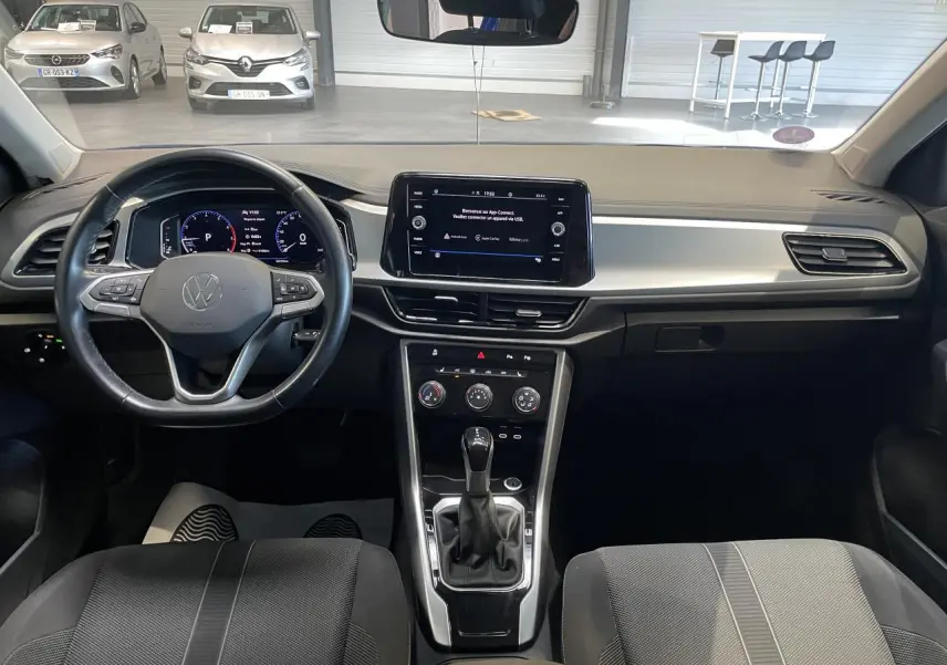 Intérieur avant du Volkswagen T-Roc bleu 2022, vue centrée sur le tableau de bord et le volant multifonction.