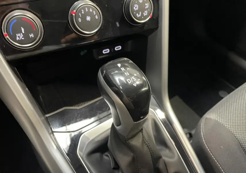 Le levier de vitesse automatique noir du Volkswagen T-Roc 1.5 TSI Evo, vu en gros plan intérieur.