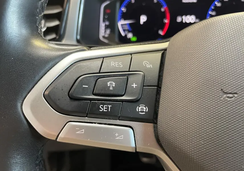 Gros plan sur les commandes de régulateur de vitesse au volant cuir noir du Volkswagen T-Roc 2022.