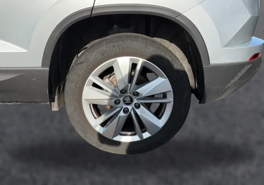 Gros plan sur la roue arrière droite gris clair d’un Skoda Karoq 2025 avec jante alu à plusieurs branches.