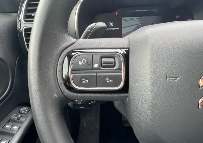 Gros plan sur le volant du Citroën C5 Aircross bleu foncé, avec commandes audio et régulateur au volant.
