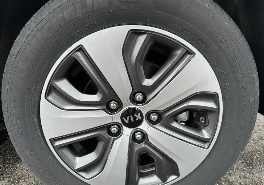 Gros plan sur la roue Michelin d'un KIA Niro blanc céleste hybride rechargeable, mettant en valeur le pneu et la jante.