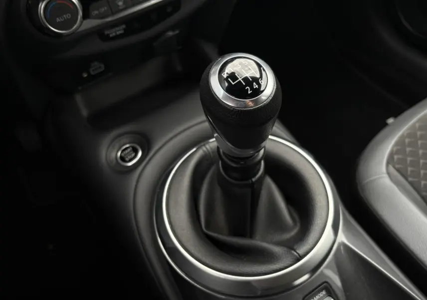 Le levier de vitesses manuel noir du Nissan Juke 2023, avec console centrale et siège partiel gris visible.