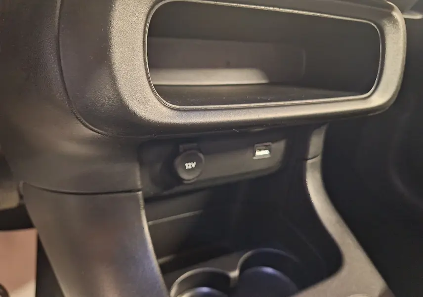 Gros plan sur la console centrale noire de la Citroën C3 1.5 BlueHDi 100 Shine avec prise 12V et port USB visibles.
