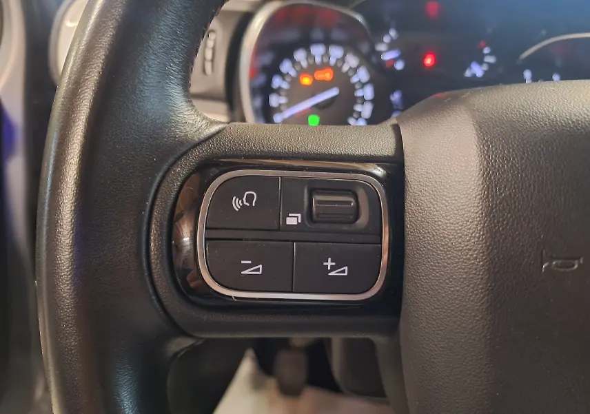 Gros plan sur les commandes vocales et volume du volant cuir noir d'une Citroën C3 1.5 BlueHDi 2019.