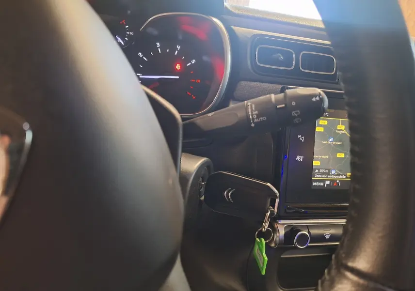 Vue rapprochée du tableau de bord et volant cuir noir de la Citroën C3 avec écran tactile GPS allumé.