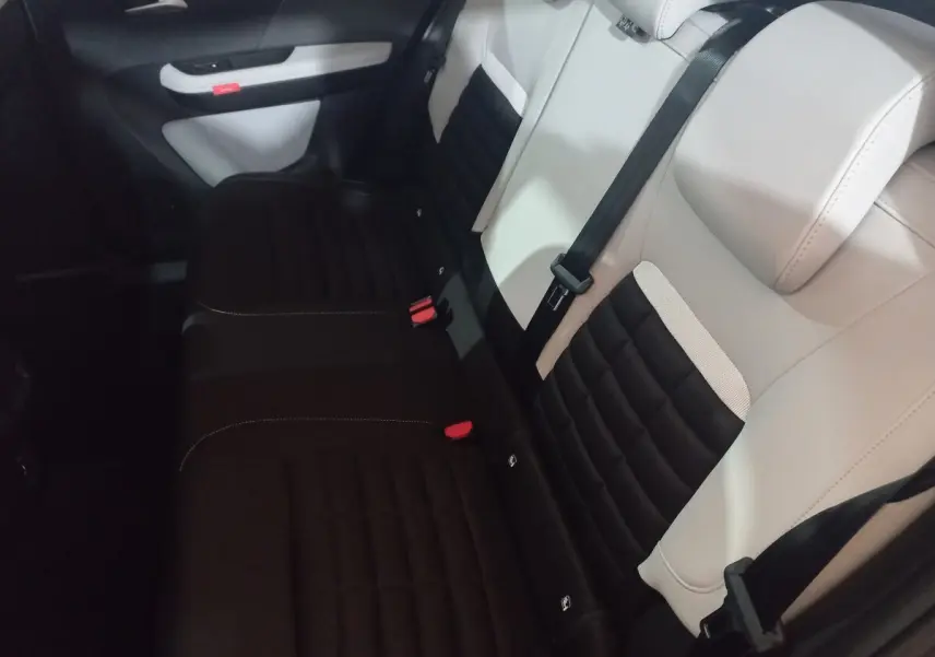 Vue intérieure côté arrière droit de la banquette bicolore noire et beige de la Citroën C3 hybride 2025.