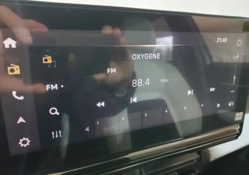 Écran tactile central de la Citroën C3 hybride gris foncé affichant la radio FM à 88,4 MHz en intérieur.