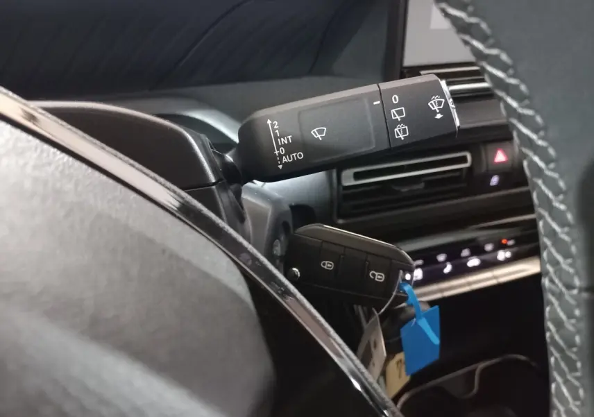 Gros plan sur la commande d’essuie-glace et la clé noire dans l’habitacle d’une Citroën C3 hybride 2025.
