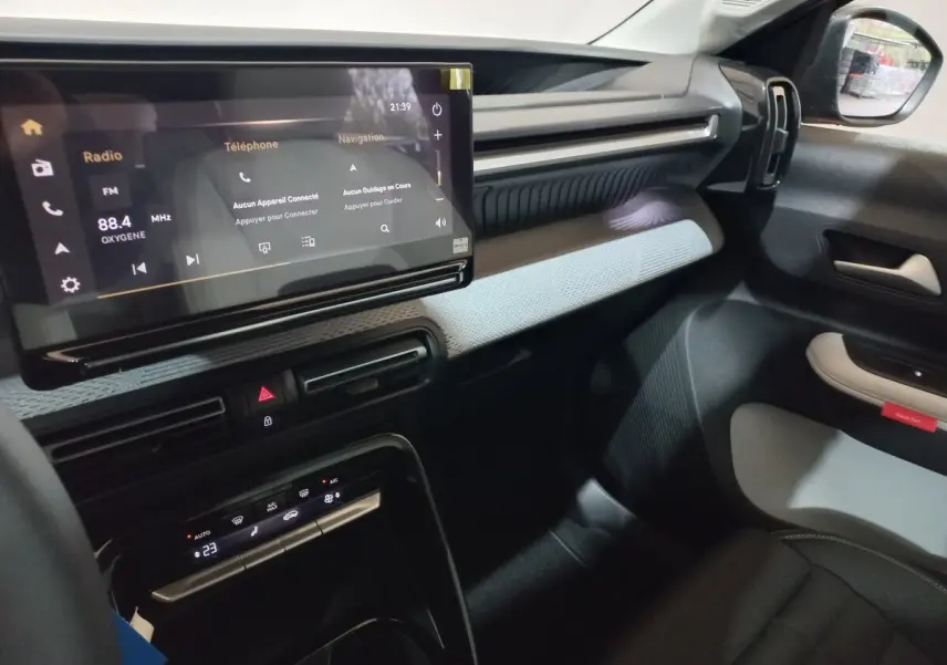 Vue intérieure côté passager de la Citroën C3 hybride gris foncé, avec écran tactile central et tableau de bord moderne.