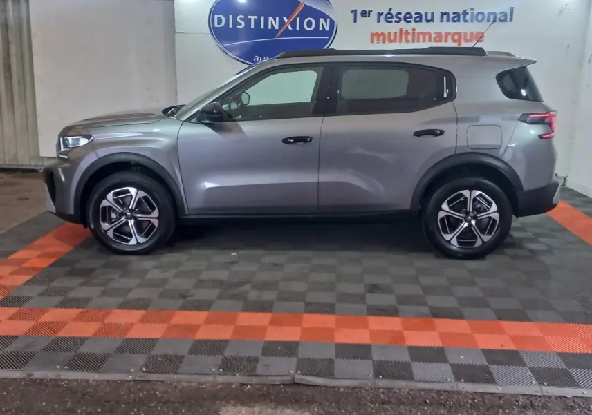 Vue latérale droite d'une Citroën C3 hybride gris foncé, avec jantes modernes et lignes épurées.