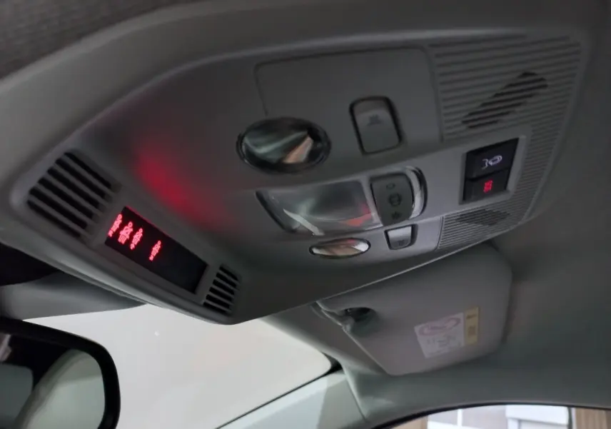 Vue intérieure du plafonnier de la Citroën C3 hybride 2025, avec commandes d'éclairage et affichage rouge.