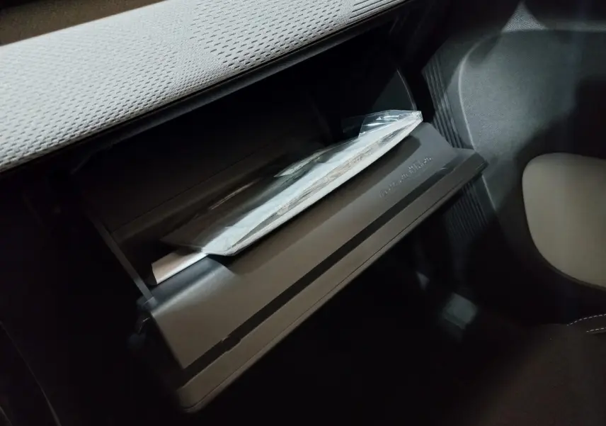 Gant de boîte à gants ouvert côté passager dans l'habitacle sombre d'une Citroën C3 hybride gris foncé 2025.