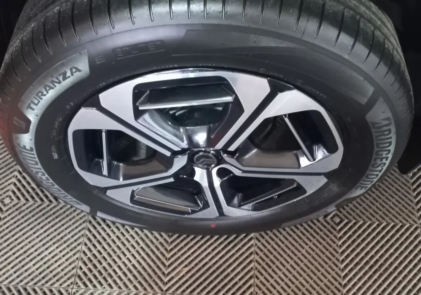 Gros plan sur la roue avant d’une Citroën C3 hybride 2025, jante alliage bicolore et pneu Bridgestone Turanza.