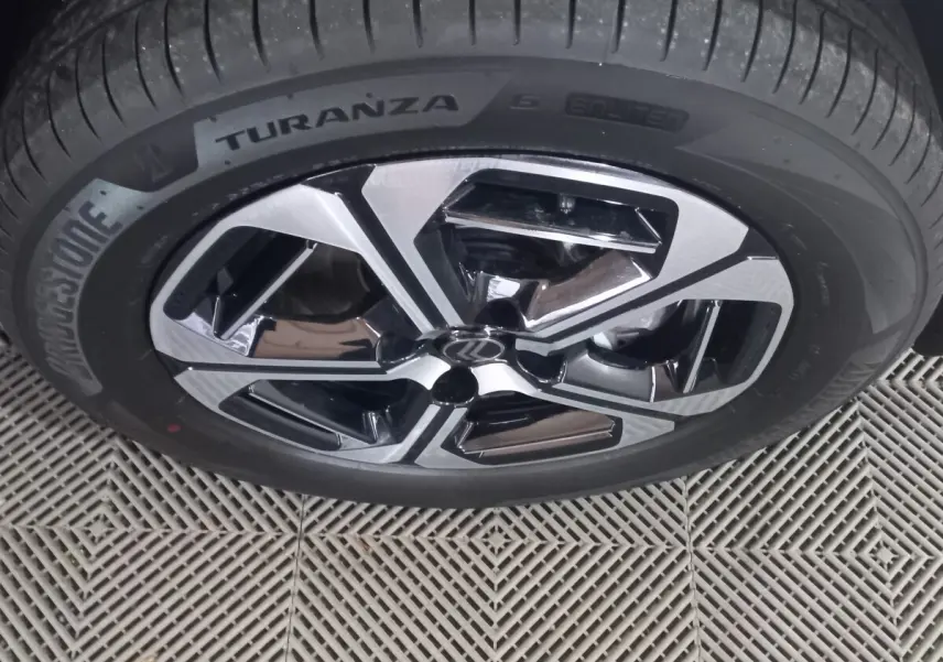 Gros plan sur la jante alliage bicolore et pneu Bridgestone Turanza d'une Citroën C3 Hybride gris foncé.