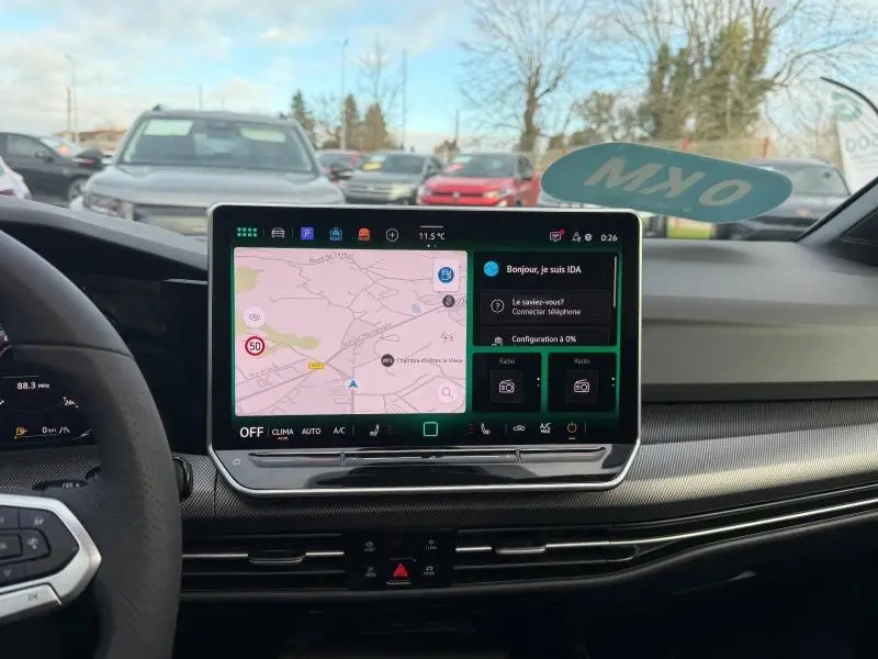 Vue intérieure du tableau de bord de la Volkswagen Golf 1.5 eTSI R-Line 2025 avec écran tactile central affichant la navigation.