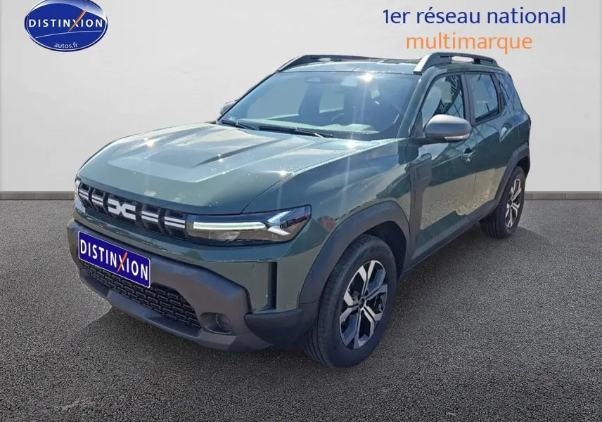 Vue 3/4 avant droit du Dacia Duster 2025 vert kaki avec jantes alu et barres de toit visibles.