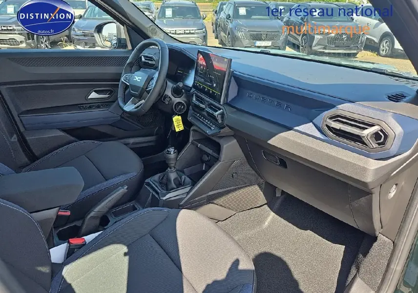 Vue intérieure côté conducteur du Dacia Duster 2025 vert kaki, avec tableau de bord moderne et boîte manuelle.